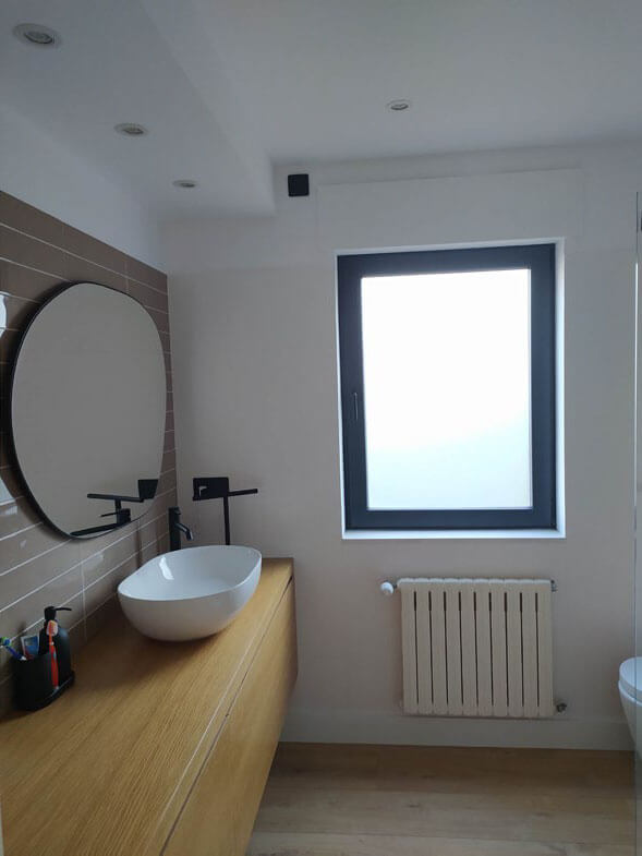 Baño elegante con espejo redondo y estufa